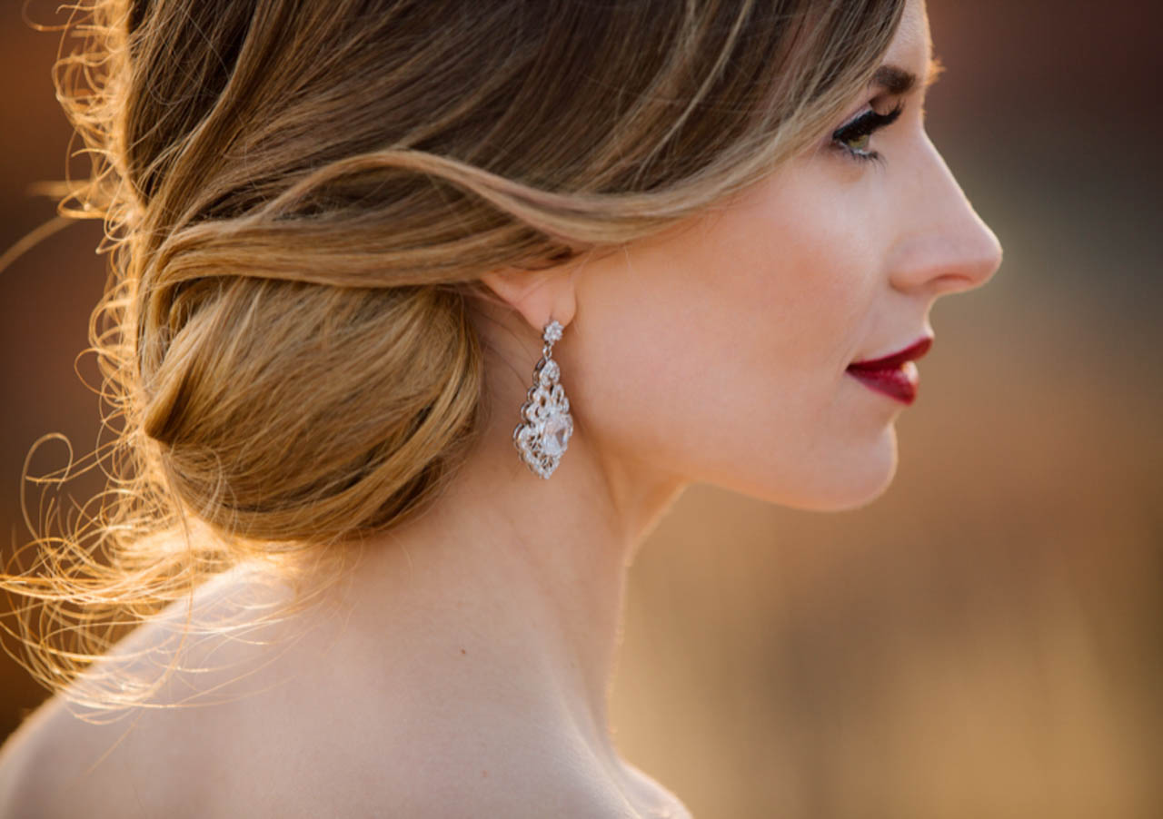 Wedding hair and makeup with warm tones and red lips.