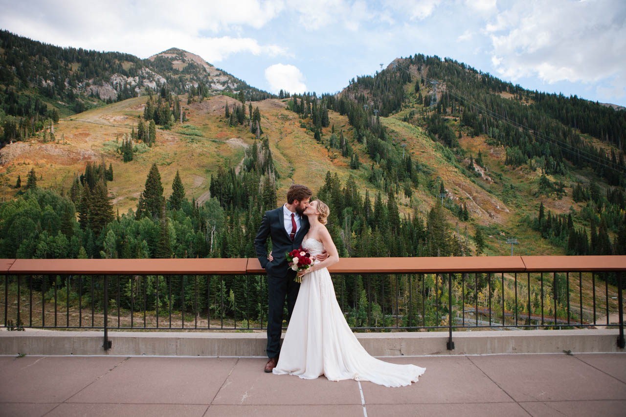 Couple kisses amid breathtaking fall mountains at Snowbird's Aerie.